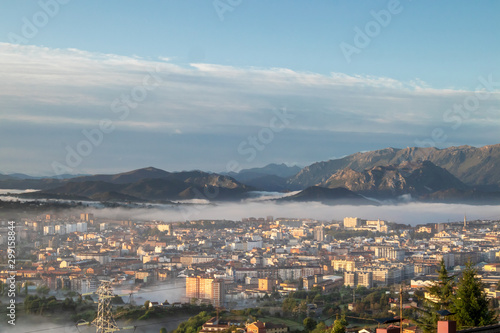 Oviedo city aerial panoramic sunrise foggy view from a mountain viewpoint near Oviedo, Spain