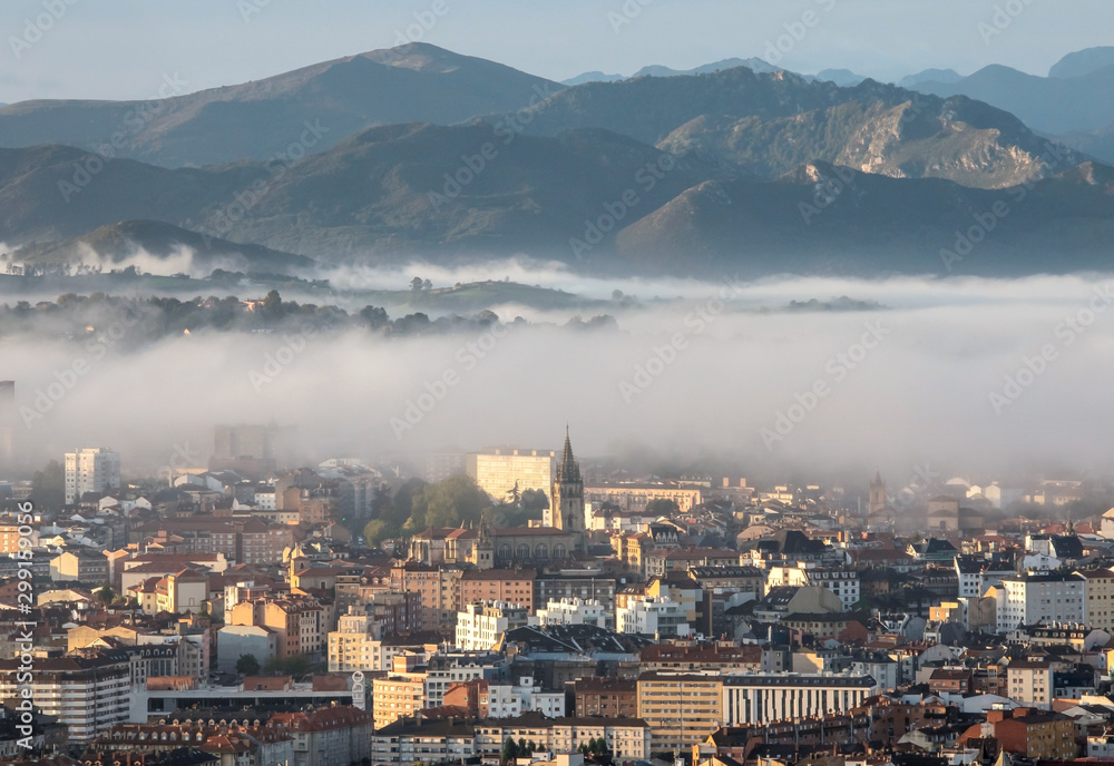 Obraz premium Oviedo city aerial panoramic sunrise foggy view from a mountain viewpoint near Oviedo, Spain