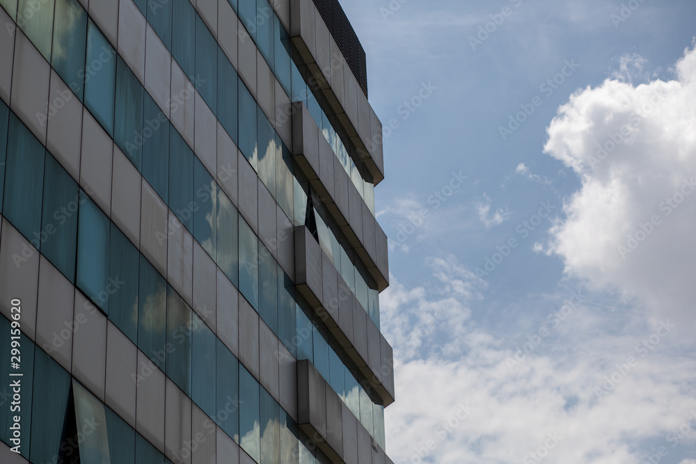 Kuala Lumpur, Malaysia – March 15, 2019. Detailed shot of the glass facade of the skyscraper, blue and beige; cloudy sky. Urban concept. Kuala Lumpur, Malaysia – March 15, 2019. Detailed shot of the glass facade of the skyscraper, blue and beige; cloudy sky. Urban concept.