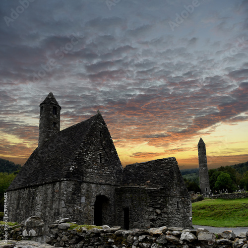 Foto view to the ruins of monastic cemetery of Glendalough, Ireland while sunset , an