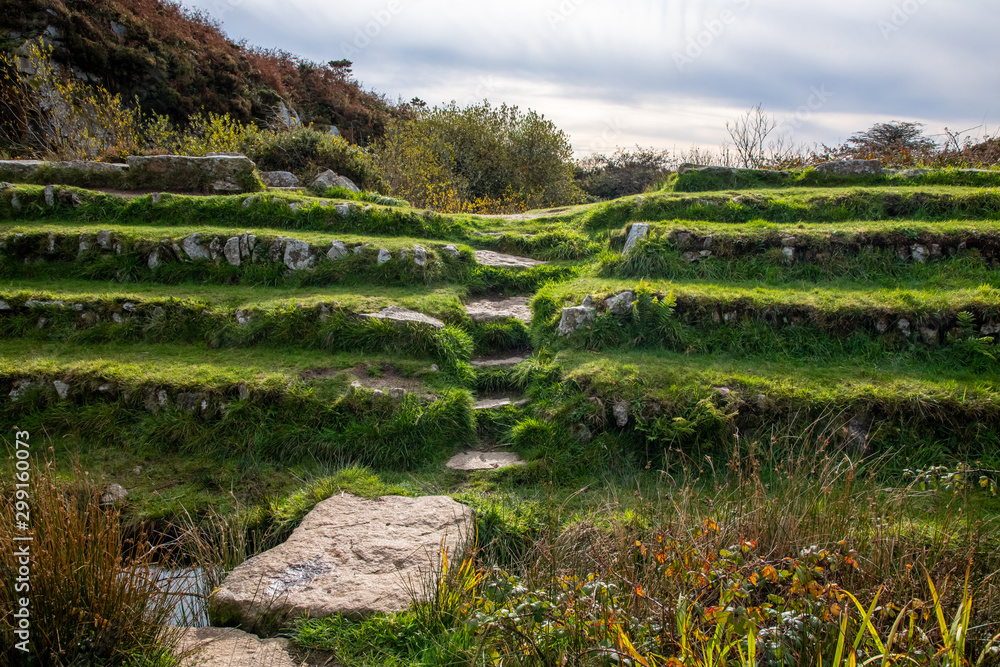 A set of worn steps between rows of seatiing in an old ruined amphitheatre