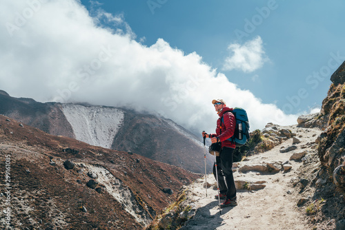 Hiker man silhouette on clouds background standing on path going over the Imja Khola valley and enjoying mountain views during an Everest Base Camp trekking route near Tengboche. Active vacation image photo