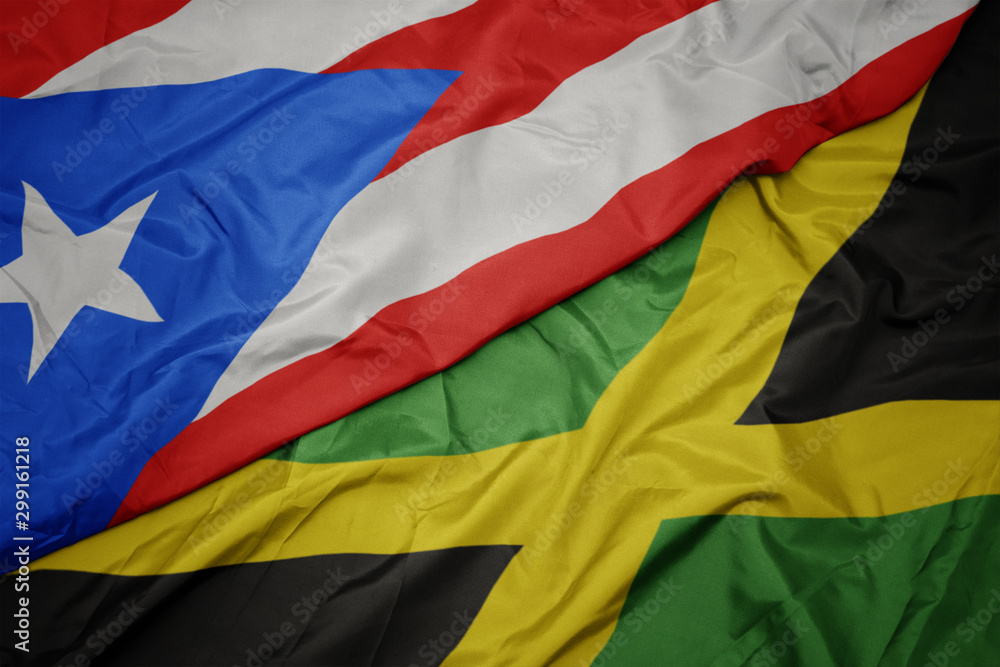 waving colorful flag of jamaica and national flag of puerto rico.