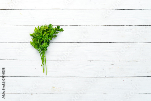 Fresh parsley on white wooden background. Top view. Free space for your text. © Yaruniv-Studio