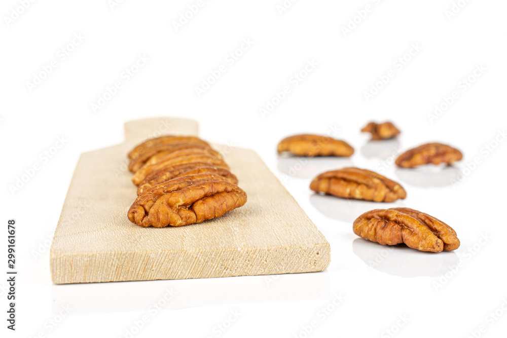 Group of ten whole dry brown pecan nut on small wooden cutting board isolated on white background Group of ten whole dry brown pecan nut on small wooden cutting board isolated on white background