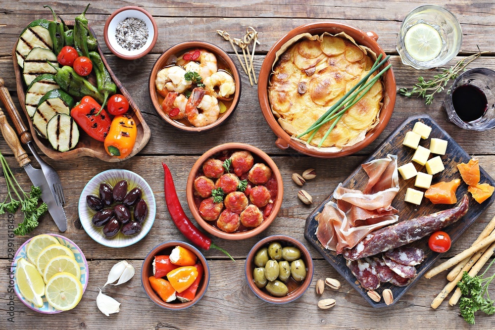 Spanish tapas. Traditional mediterranean appetizer table concept included tortilla, grilled vegetables, meatballs, garlic king prawns,olives and cured meat. Spanish tapas. Traditional mediterranean appetizer table concept included tortilla, grilled vegetables, meatballs, garlic king prawns,olives and cured meat.