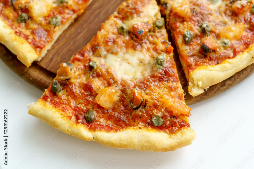 Cut into slices italian pizza with seafood on white background Cut into slices italian pizza with seafood on white background