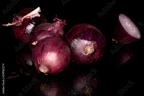 Group of four whole one half of tasty onion red isolated on black glass