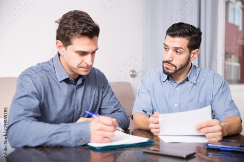 Tableau sur toile Two serious males with documents at table