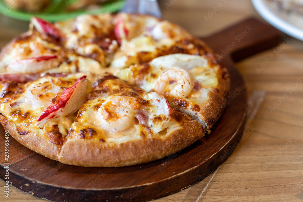 Seafood Italian Pizza slice on wood dish Seafood Italian Pizza slice on wood dish