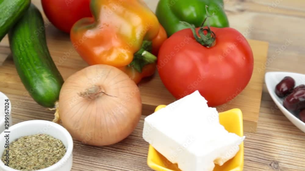 Ingredients for a Greek salad on wooden table. Vegetarian cuisine. Healthy food. Greek salad recipe execution. Fresh vegetables for salad. Olive oil, Olives, Feta cheese, tomatoes. Ingredients for a Greek salad on wooden table. Vegetarian cuisine. Healthy food. Greek salad recipe execution. Fresh vegetables for salad. Olive oil, Olives, Feta cheese, tomatoes.