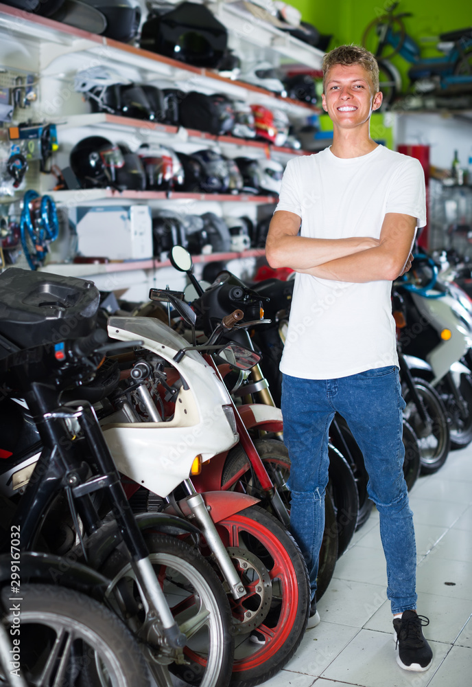 Portrait of smiling male standing near the bike in the shop