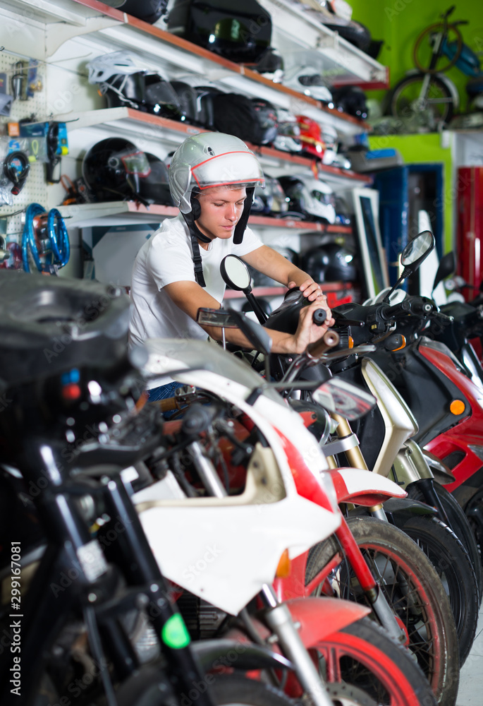 Smiling man in helmet is sitting on motorbike