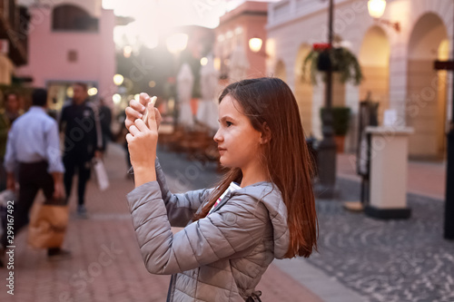 Teen girl walking and taking a picture in an old city photo