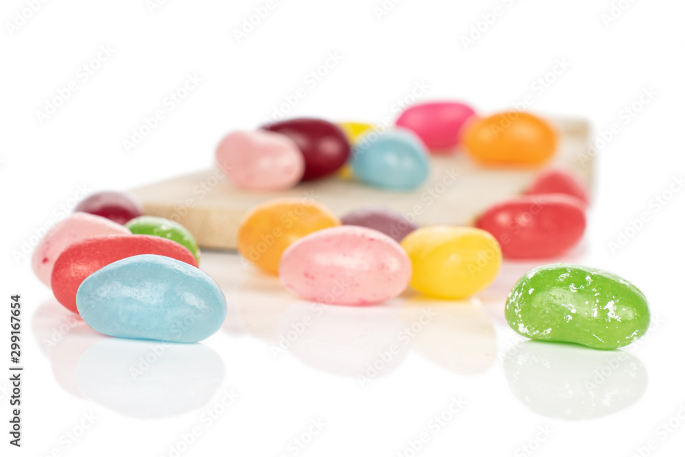 Lot of whole jelly bean candy on wooden cutting board isolated on white background Lot of whole jelly bean candy on wooden cutting board isolated on white background