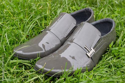 gray shoes on the grass,modern gray men's shoes on grass in spring