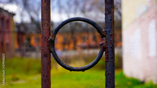 rusty metal ring on a fence against the background of old houses