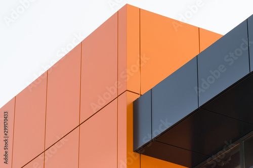 Geometric color elements of the building facade with planes  lines  corners with highlights and reflections for the abstract background and texture of red  orange  gray colors. Place for text