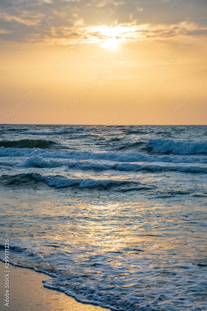 Beautiful sunset on the Baltic Sea with waves and reflections on the water