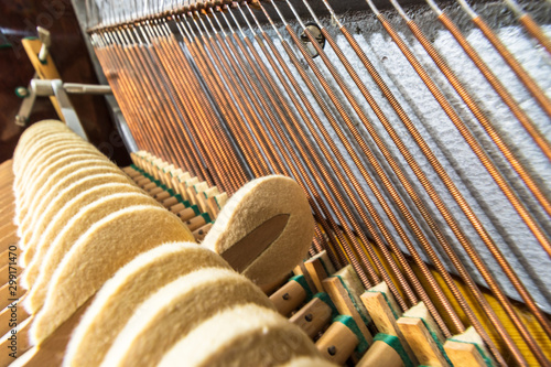 The one hammer of fortepiano forming a chord. Details inside of the piano with hummer and piano-strings. Close view. photo