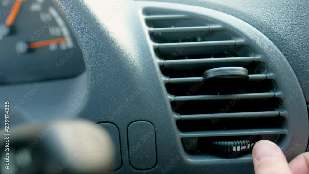 Close-up of hand adjusting air vents to change wind direction inside the car. Too cool or too warm air condition. Close-up of hand adjusting air vents to change wind direction inside the car. Too cool or too warm air condition.