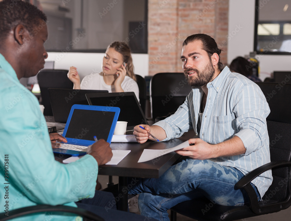 Man sharing business ideas with African colleague