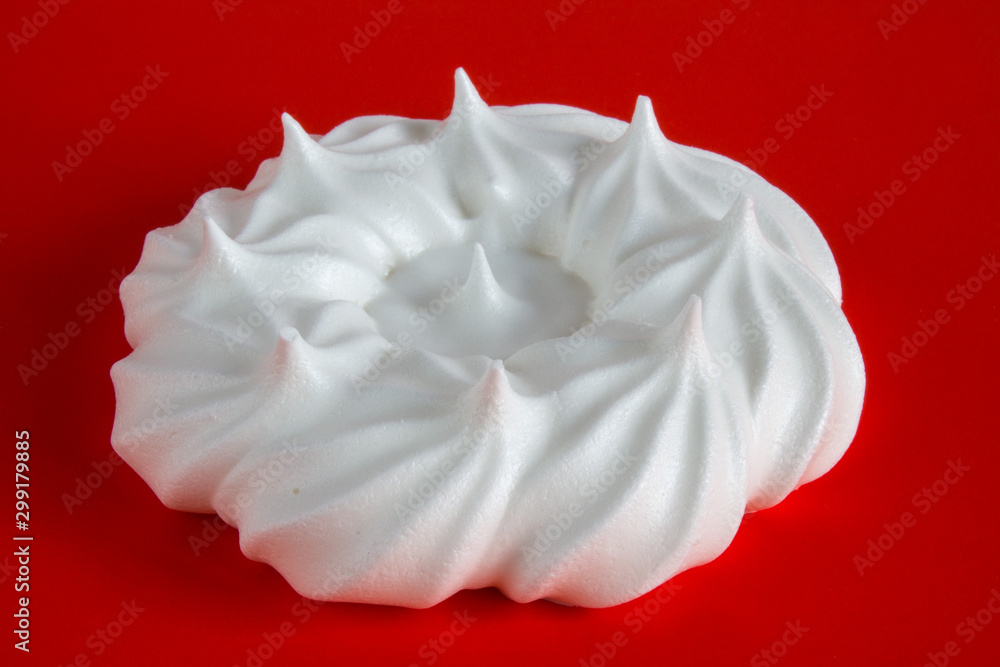 Obraz premium white meringue on red background close up