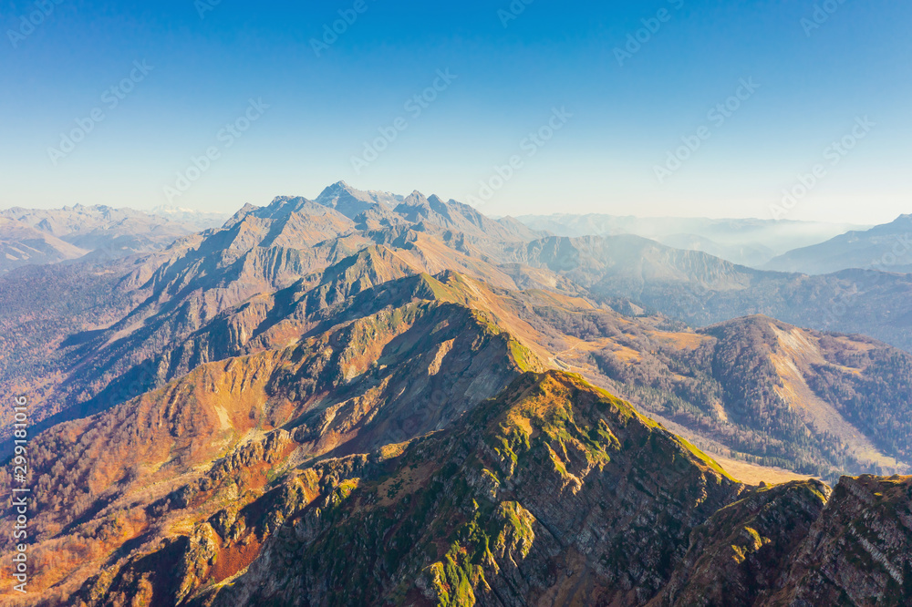 Large rocky mountain range with peaks and troughs, aerial view on a clear sunny day with good weather.