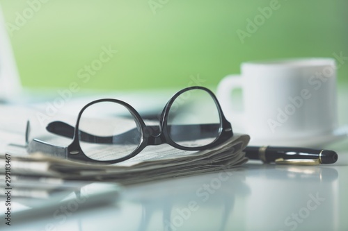 Newspapers with glasses and laptop. Online news.