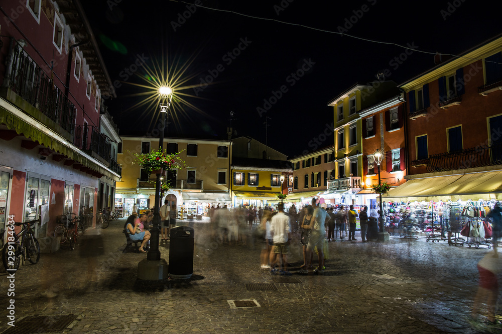 Crowded marketplace in the town center at night. Caorle, Italy.