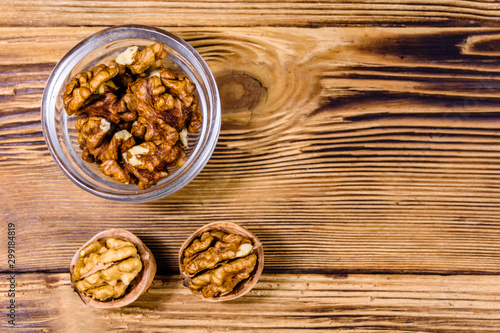 Cores of walnut in glass bowl on a wooden table. Top view