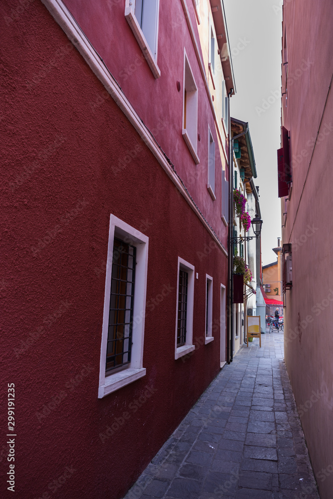 Narrow passage between colorful old buildings in city center. Caorle Italy Narrow passage between colorful old buildings in city center. Caorle Italy