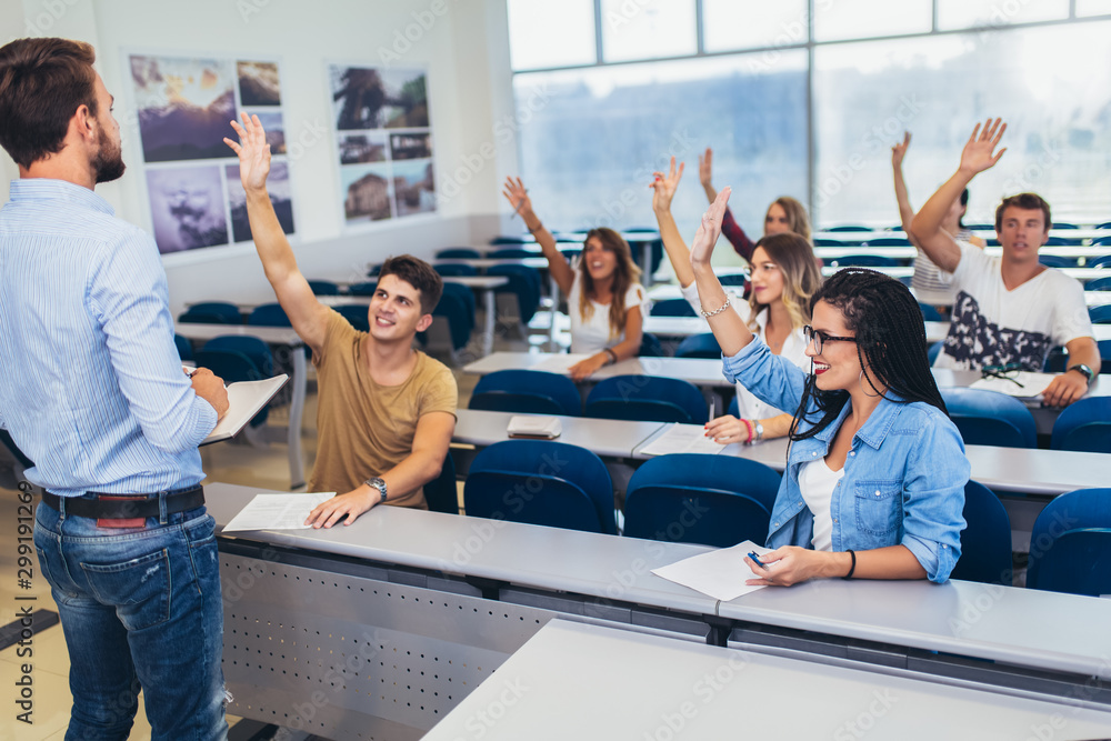 Fototapeta premium Group of students raising hands in class on lecture