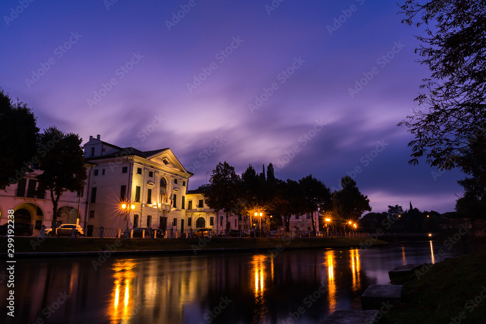 Picturesque view on the Sile river in the city center with a stunning purple sky and lights reflections on the water at night Treviso Italy