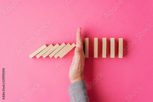 Cuadro en lienzo Top view of male hand interrupting collapsing dominos