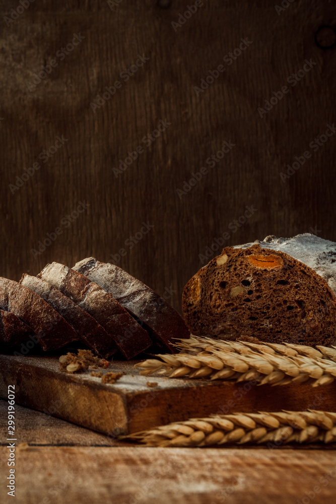Freshly baked wheat bread, homemade cakes, still life with bread, crisp loaf of bread, still life on a rustic background, top view, rustic bread, roll, loaf.