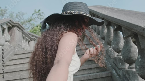 Attractive young beautiful curly-haired girl pulls arm of her boyfriend at a staircase. Tourist couple. POV. Slow motion. Rio de Janeiro, Brazil. Cinematic 4K. photo