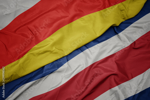 waving colorful flag of costa rica and national flag of south ossetia.