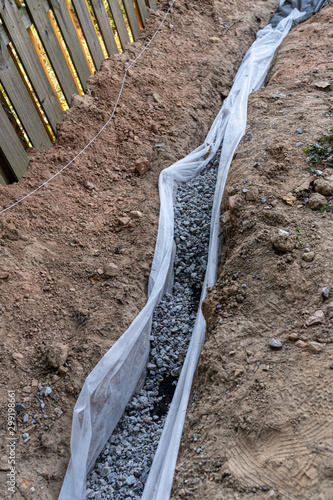 Drainage Rock in a French drain as part of a DIY home repair of drainage issues