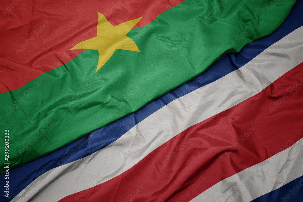 waving colorful flag of costa rica and national flag of burkina faso.