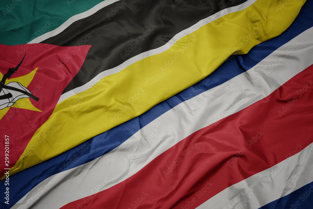 waving colorful flag of costa rica and national flag of mozambique.