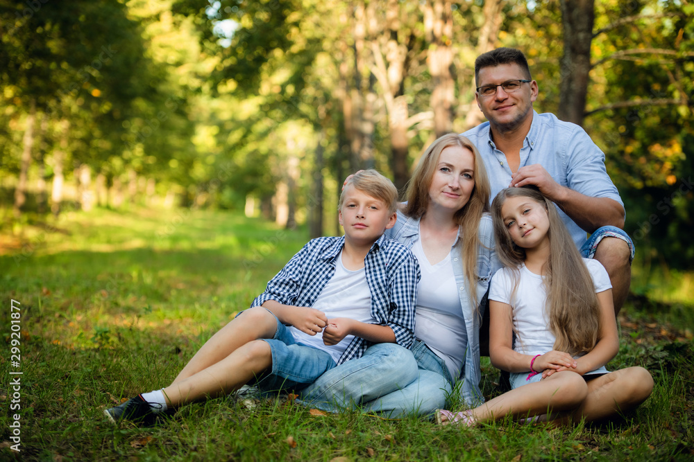 Happy family sitting outdoors sitting on a grass