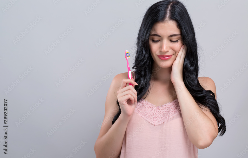 Young woman with a toothache on a gray background Young woman with a toothache on a gray background