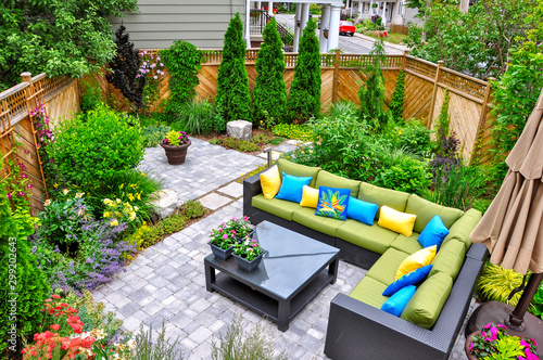 A beautiful small, urban backyard garden featuring a tumbled paver patio, flagstone stepping stones, and a variety of trees, shrubs and perennials add colour and year round interest Fototapeta