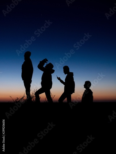 Murais de parede Silhouette of men ascending hill