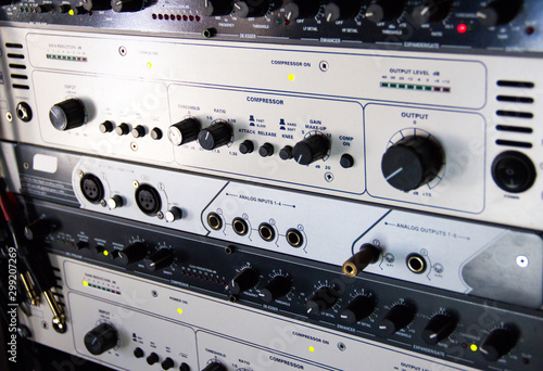 A rack of audio compressors in a recording studio