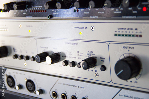 A rack of audio compressors in a recording studio.