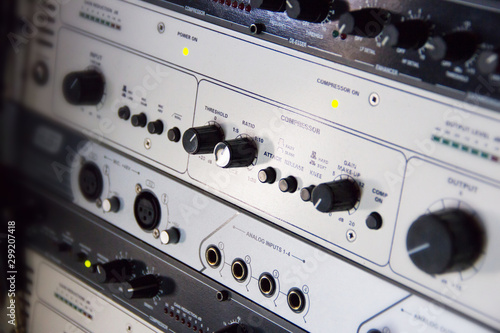 A rack of audio compressors in a recording studio.