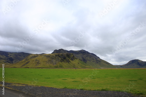 Paisaje  en Islandia con cielo azul y pastos verdes y campo de lava