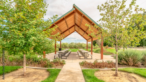 Panorama frame Beautiful view of a picnic pavilion at a park with pathway and trees in front